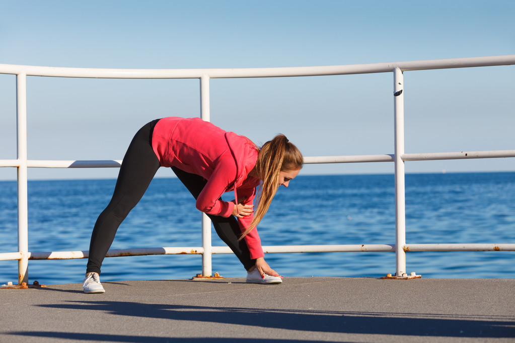 Жінка робить спортивні вправи на відкритому повітрі на узбережжі
 - Фото, зображення
