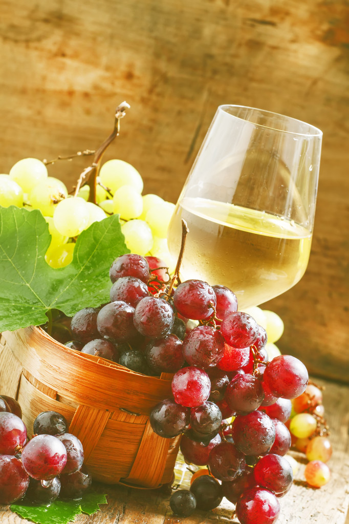 White wine in a glass and green and red grapes  - Photo, Image