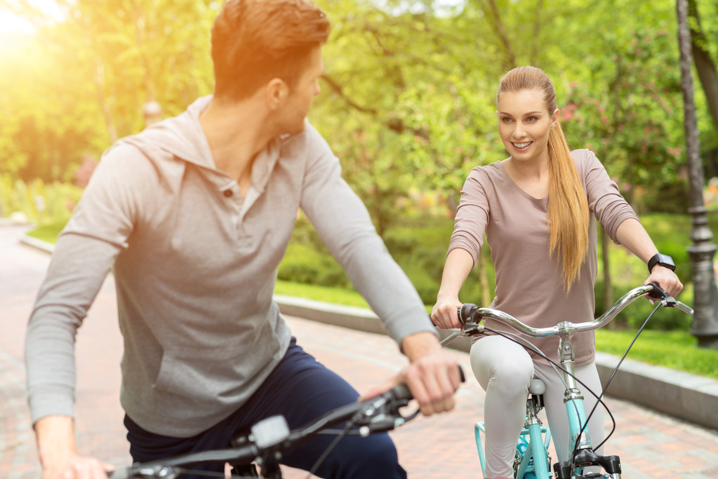 Χαριτωμένο άνδρας και γυναίκα ποδήλατο στο πάρκο - Φωτογραφία, εικόνα