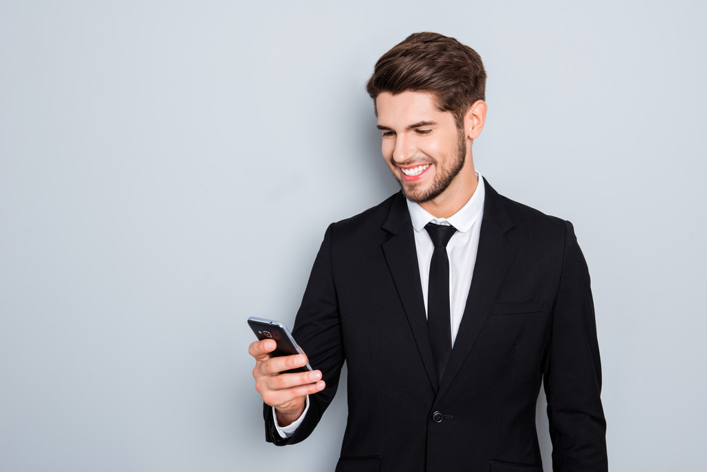 Jovem empresário alegre no terno leitura sms no smartphone
 - Foto, Imagem