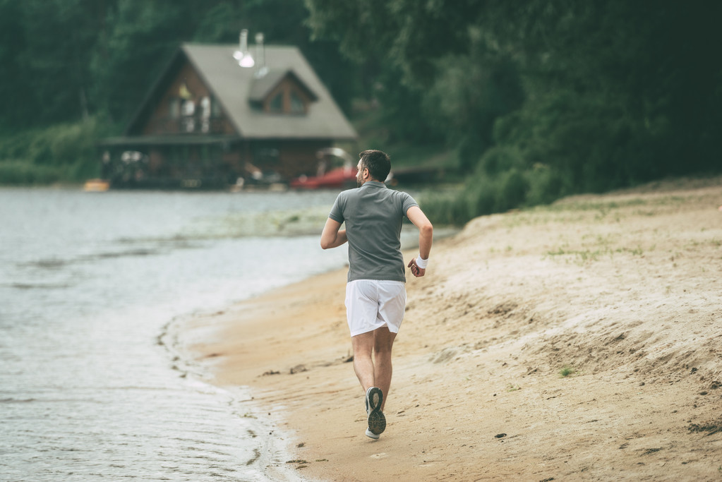 Hombre corriendo por la orilla del río
   - Foto, imagen