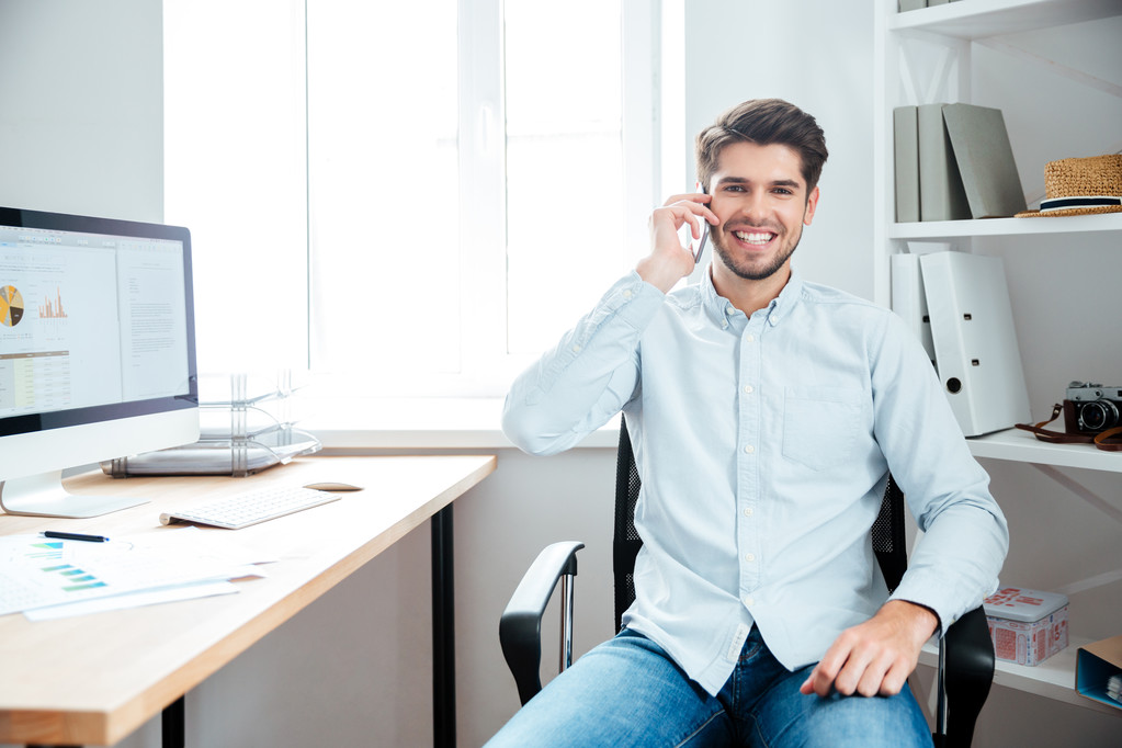 Üzletember ül a munkahelyére, a Hivatal mozgatható telefon - Fotó, kép