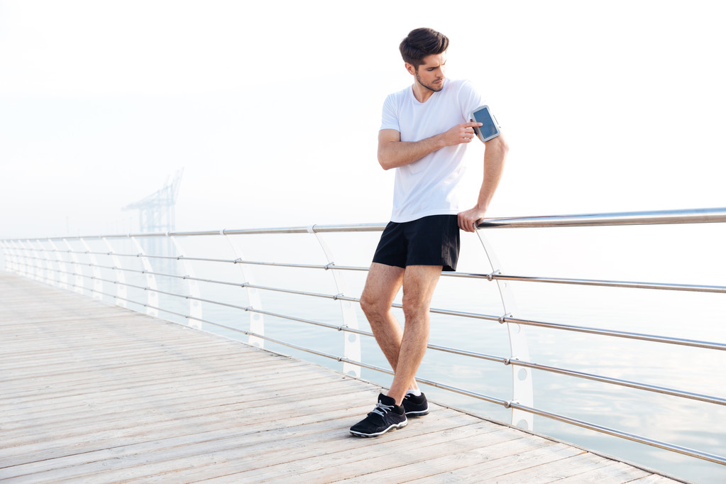 A karszalag használ üres képernyő smartphone férfi atléta - Fotó, kép