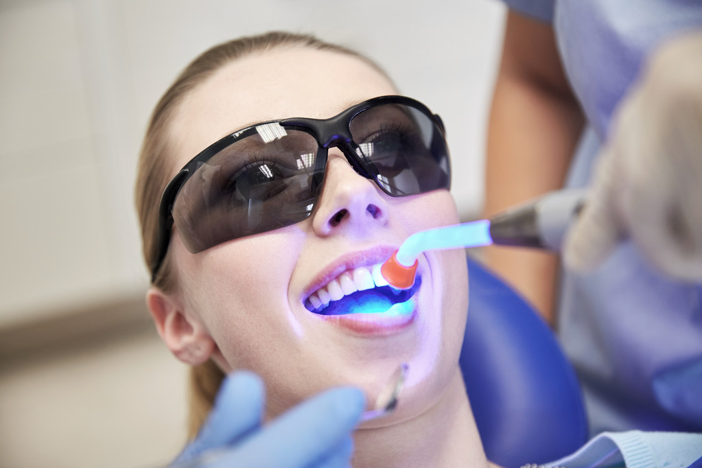 κοντινό πλάνο γυναίκα ασθενή με οδοντιατρική θεραπεία φως - Φωτογραφία, εικόνα