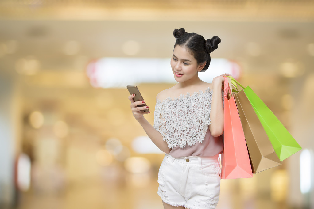 Alışveriş torbaları ile akıllı telefon tutan çekici alışveriş kadın - Fotoğraf, Görsel