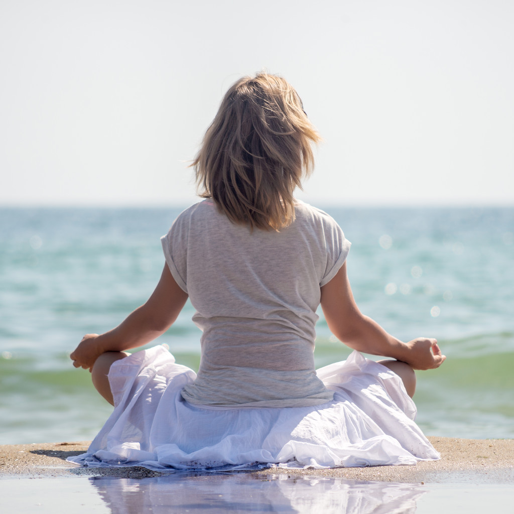 Kobieta medytująca nad morzem - Zdjęcie, obraz