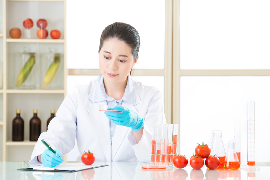 Azjatyckich kobiet naukowców myślenia i przytrzymując pomidor - Zdjęcie, obraz