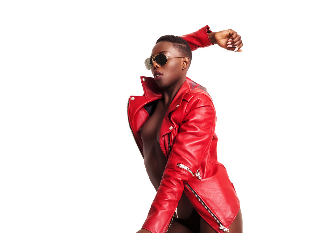 wunderschöne afrikanische Modell trägt rote Jacke und Sonnenbrille, während p - Foto, Bild