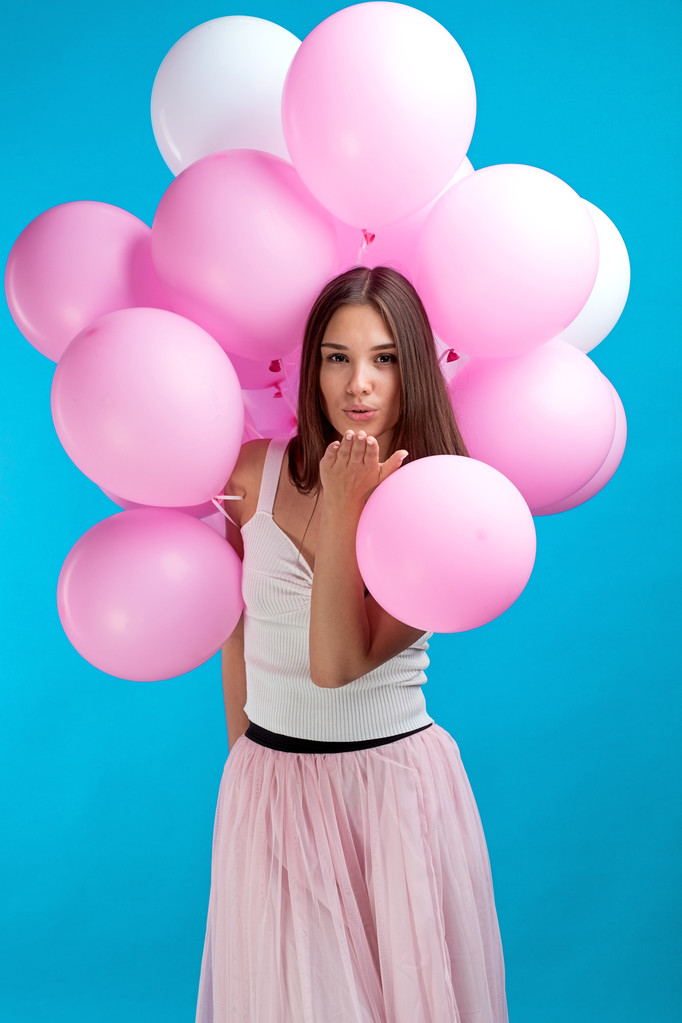 Retrato de chica bonita con globos de aire rosa soplando beso de aire en la camera.Isolate
 - Foto, Imagen