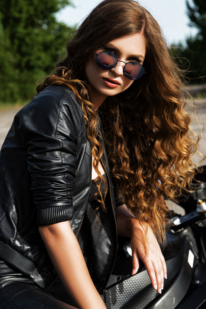 Szexuális motoros nő visel fekete bőrkabát vele sport motorkerékpár egy autópályán. Szépség, divat. Kalandtúra és szabadság. - Fotó, kép