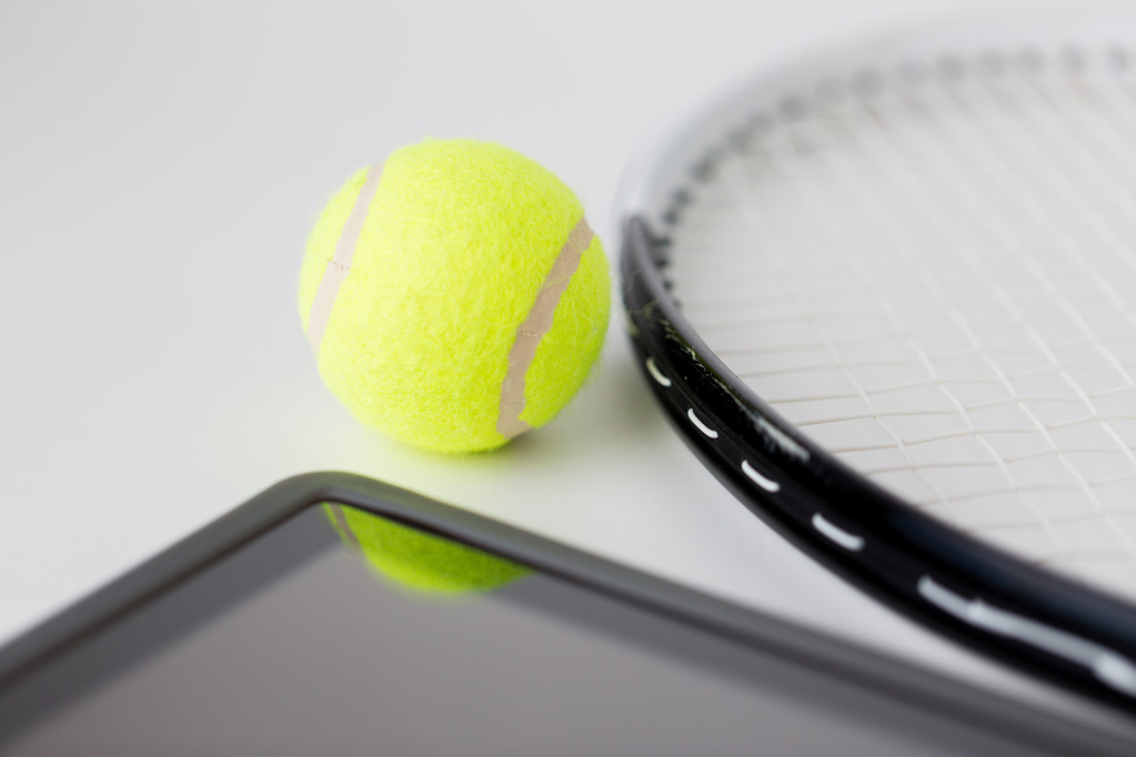 κοντινό πλάνο ρακέτα του τένις με μπάλα και tablet pc - Φωτογραφία, εικόνα