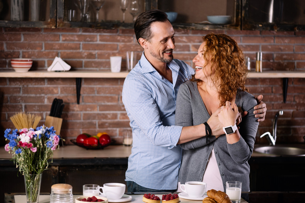 Mann umarmt Frau in Küche - Foto, Bild