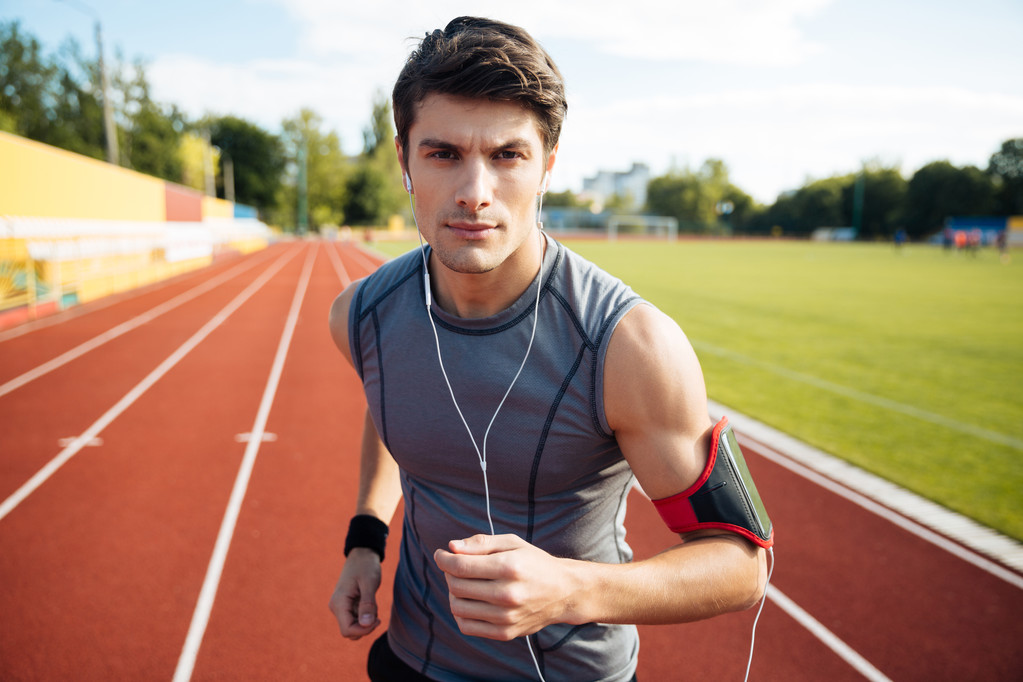Retrato de cerca de un deportista corriendo con auriculares
 - Foto, Imagen