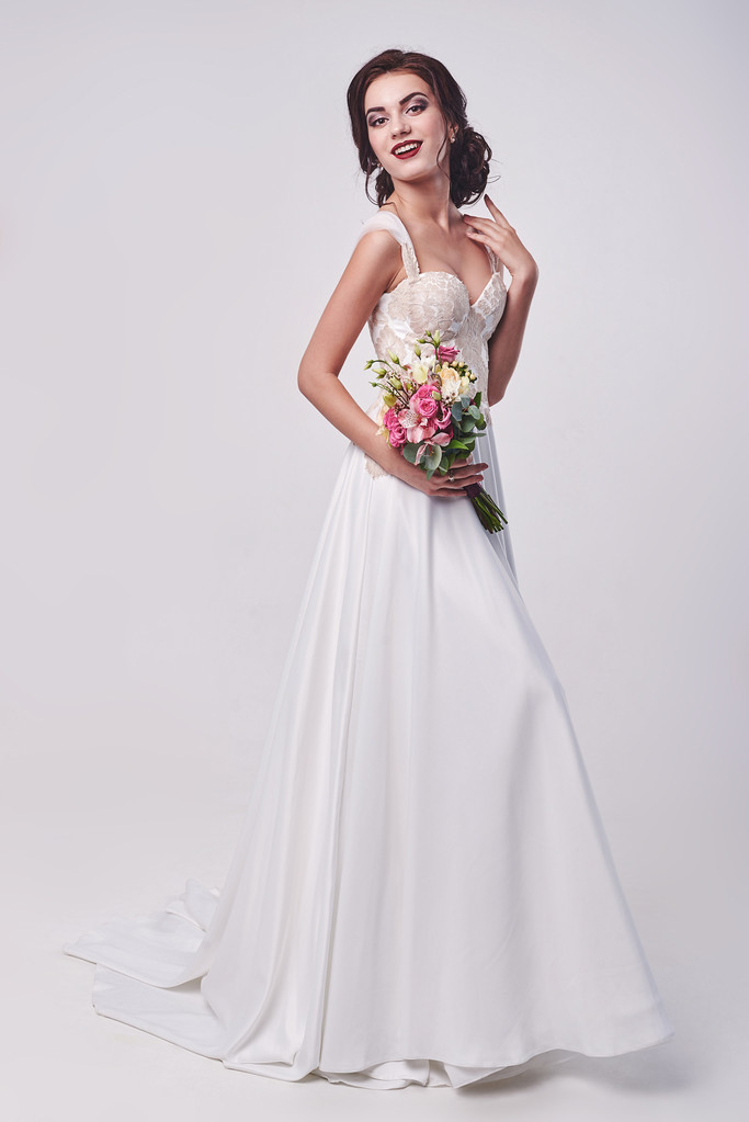 Mujer en vestido de novia con ramo de flores
. - Foto, imagen