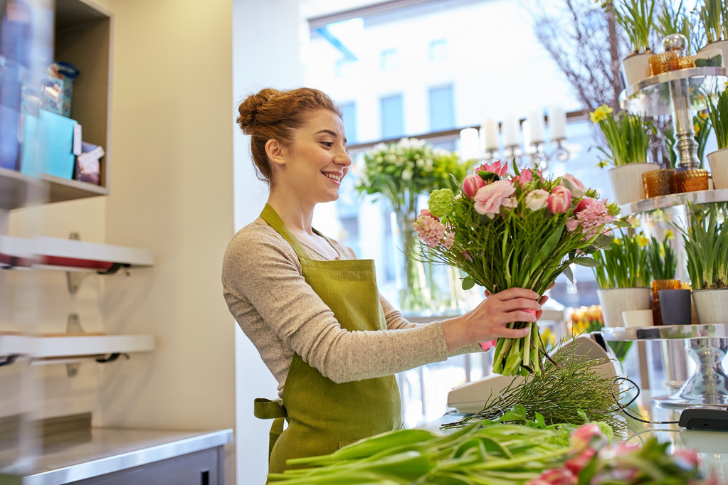 sonriente florista mujer haciendo ramo en floristería
 - Foto, Imagen
