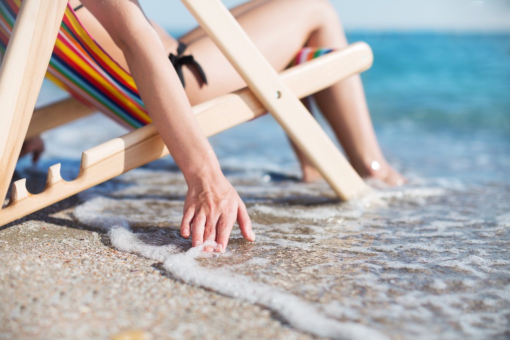 Mulher na praia relaxante na cadeira
 - Foto, Imagem
