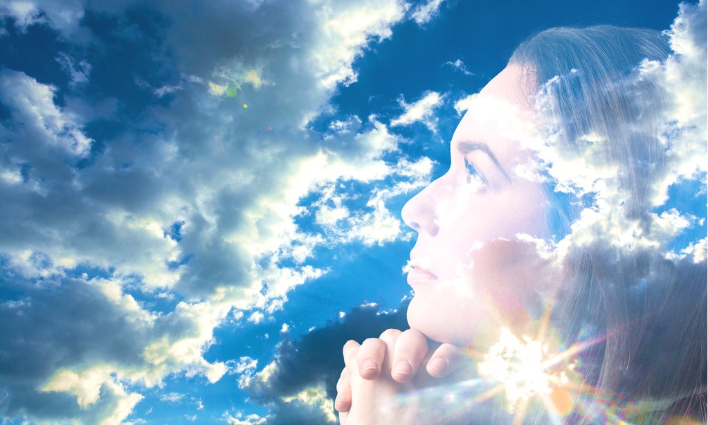 Γυναίκα προσεύχεται πάνω από το γαλάζιο του ουρανού - Φωτογραφία, εικόνα