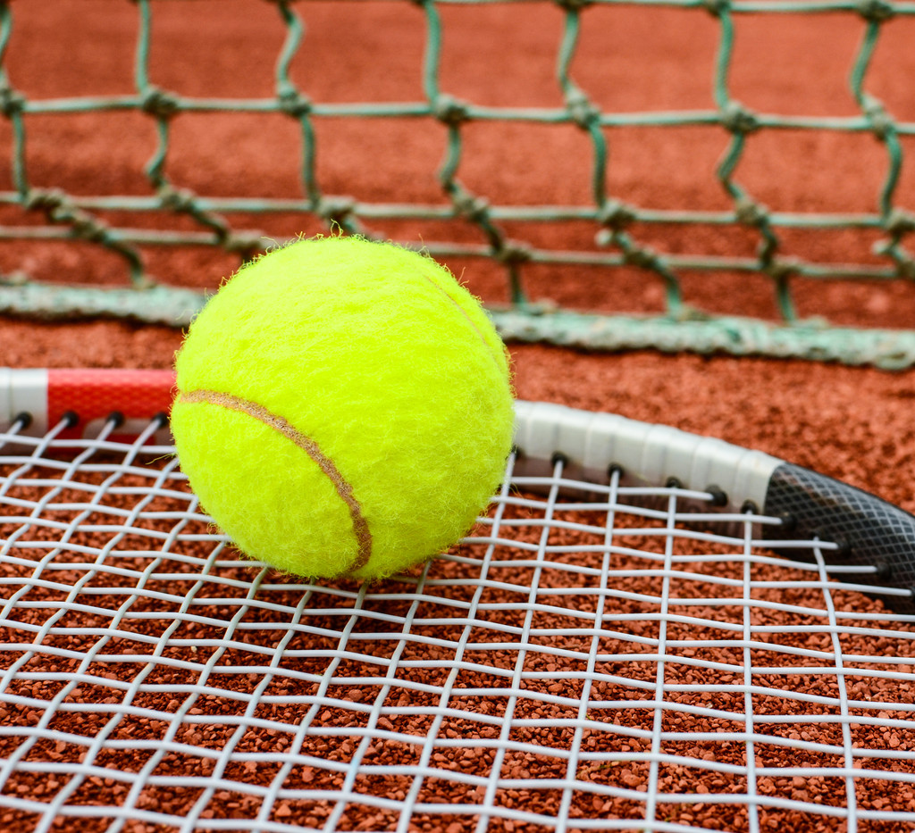 Tennis racket with ball on it clay on clay court - Photo, Image