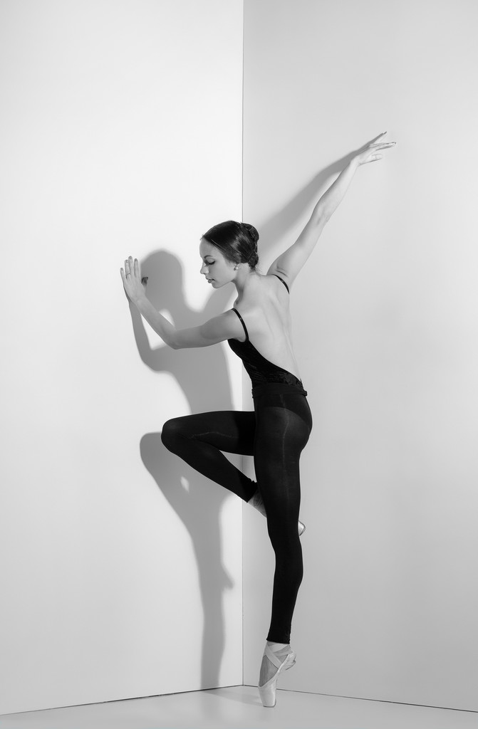 Bailarina en traje negro posando en zapatos puntiagudos, fondo de estudio
. - Foto, Imagen