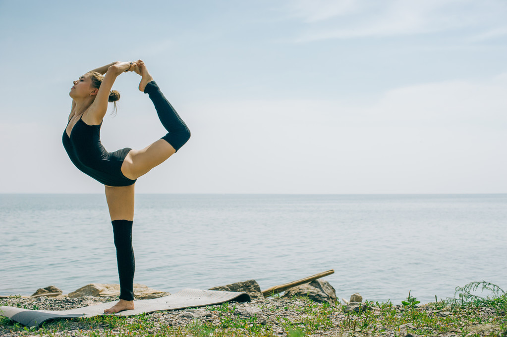 giovane donna è impegnata nella meditazione, stretching, yoga sullo sfondo della spiaggia
 - Foto, immagini