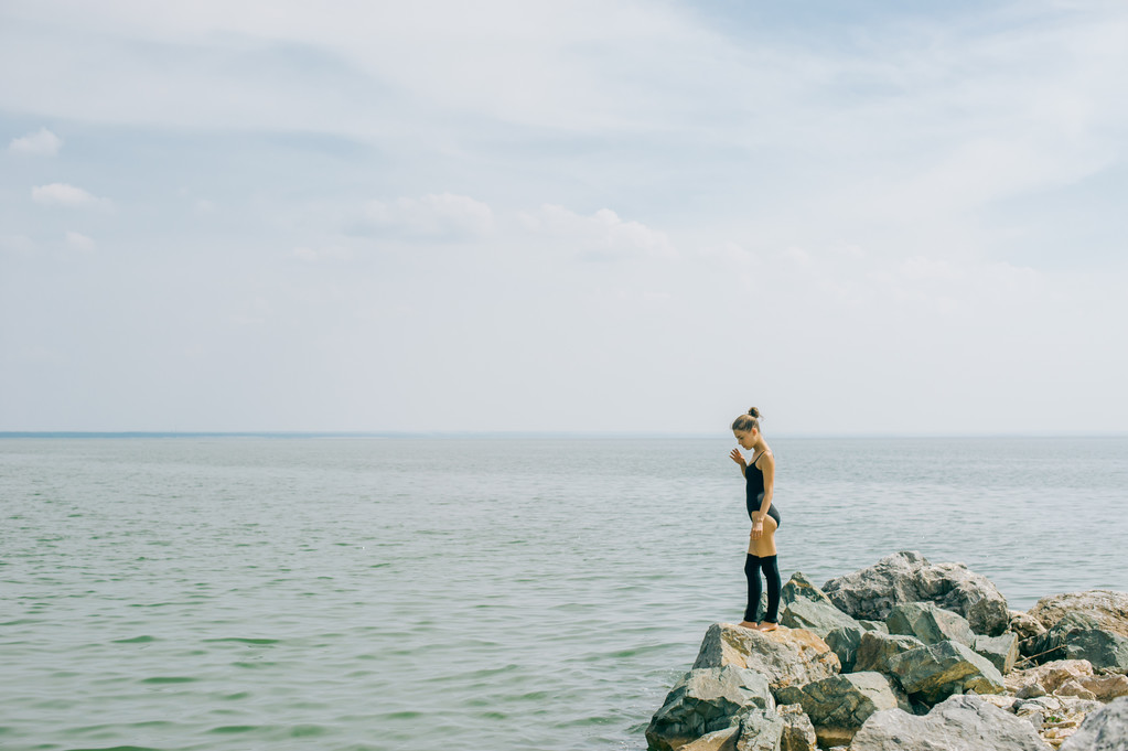 genç kadın meditasyon, germe, yoga plaj arka plan üzerinde nişanlandı - Fotoğraf, Görsel