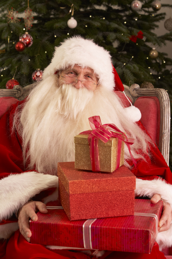 Санта-Клауса, сидячи в крісло перед Різдвяна ялинка - Фото, зображення