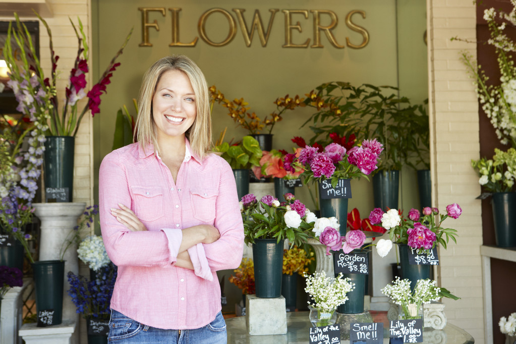 Nainen seisoo ulkopuolella kukkakauppias
 - Valokuva, kuva