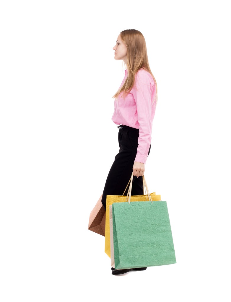 Vista trasera de la mujer que va con bolsas de compras
 - Foto, imagen