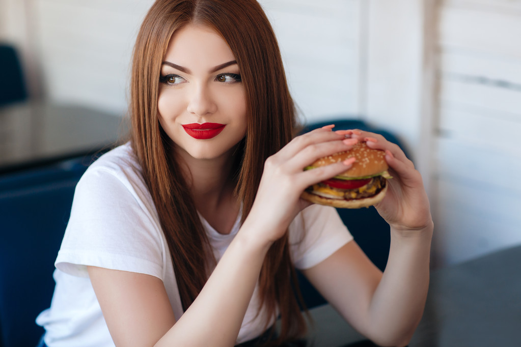 Леди с гамбургером за столик в кафе
 - Фото, изображение