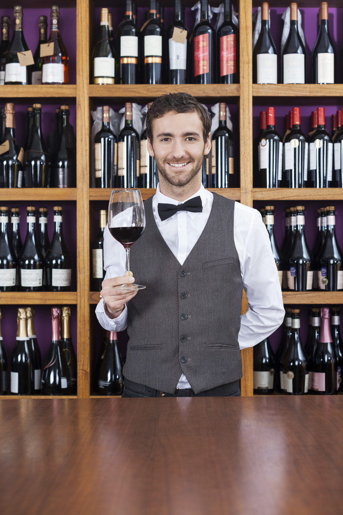 Barman drží sklenka na červené víno na přepážce - Fotografie, Obrázek