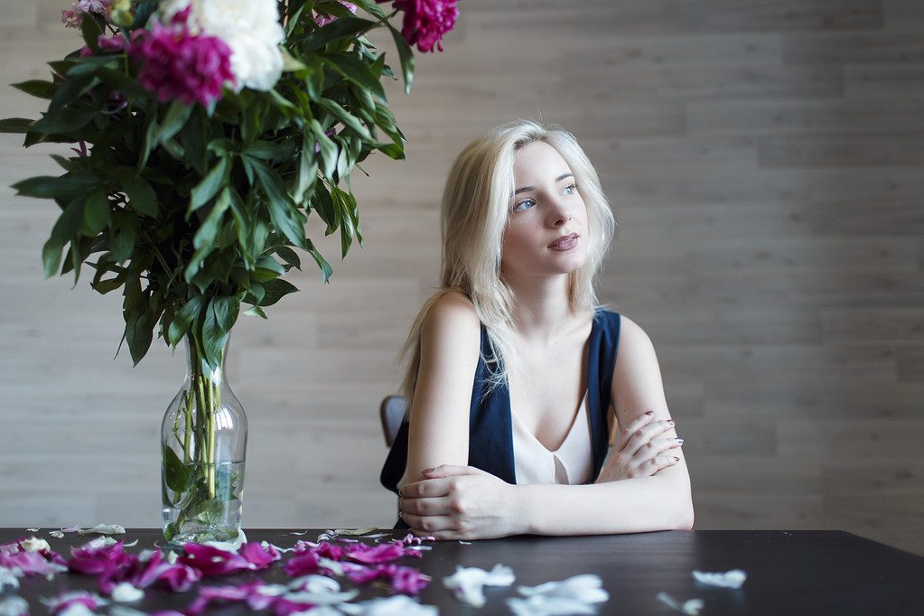Портрет красивой блондинки за столом
 - Фото, изображение