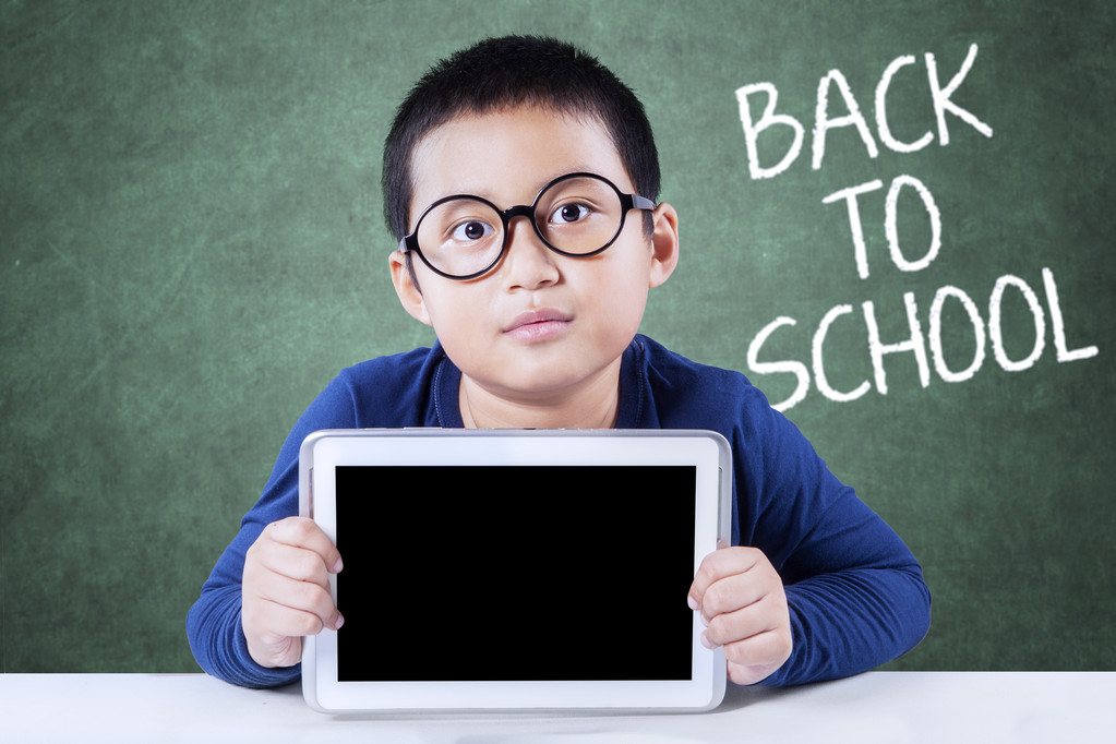 Little schoolboy back to school and holds tablet - Photo, Image