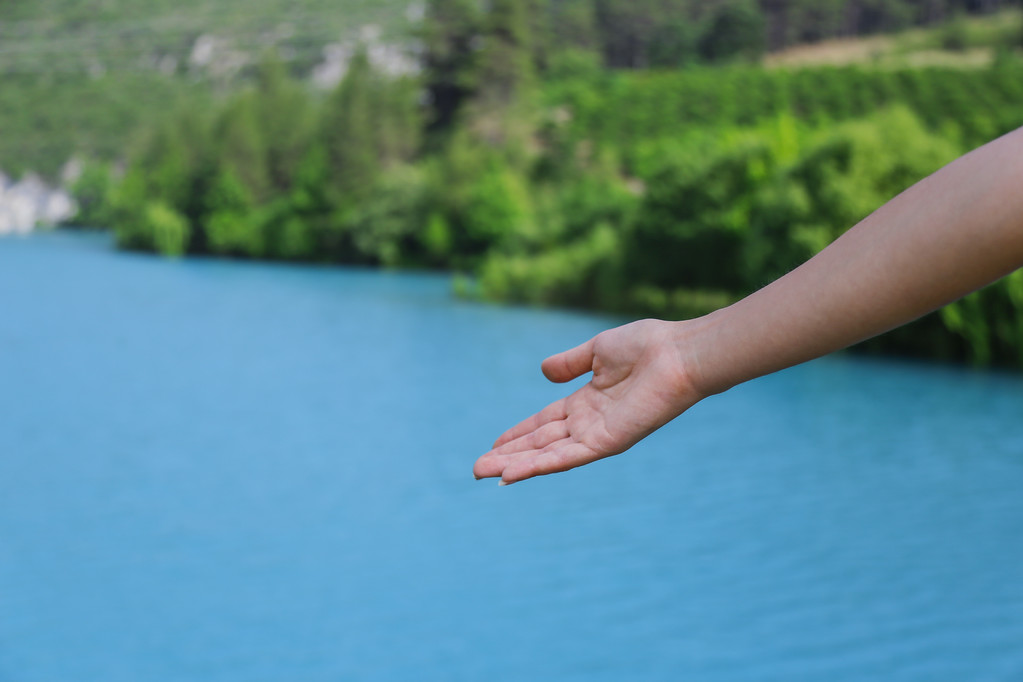 Mujer punto de la mano en el lago azul
 - Foto, Imagen