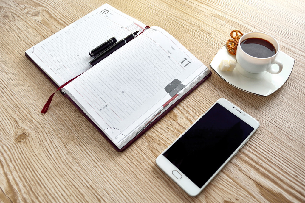 notebook aperto, telefono con tazza di caffè sulla scrivania in legno
 - Foto, immagini