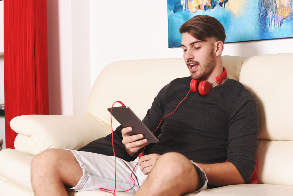 Молодой человек слушает музыку с планшетом
  - Фото, изображение