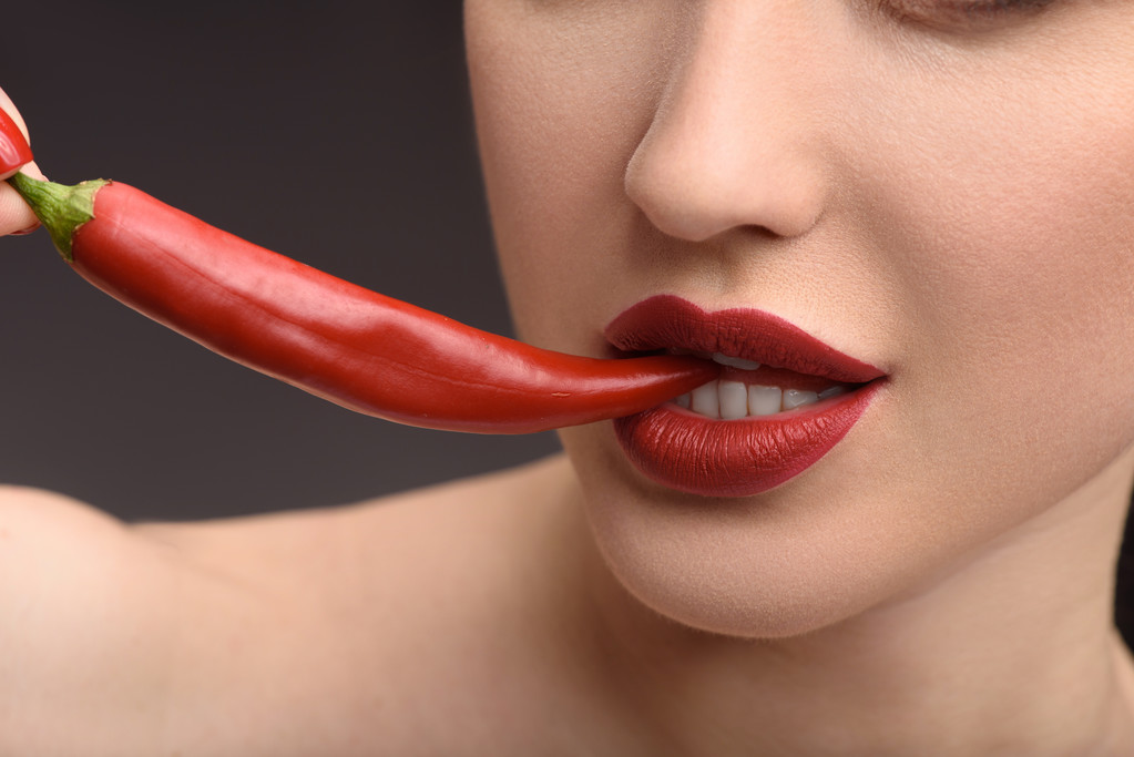 Страстная женщина, кусающая горячий чили
 - Фото, изображение