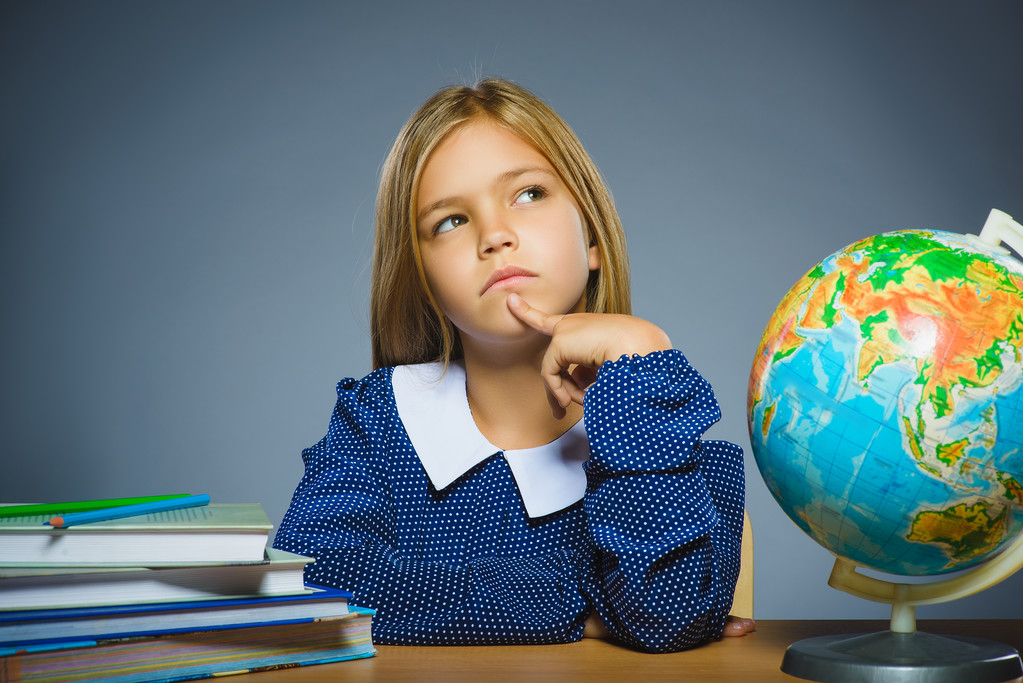 έννοια σχολείο. το κορίτσι σκέφτεται ή να κάθεται στο γραφείο του στην τάξη γεωγραφία - Φωτογραφία, εικόνα