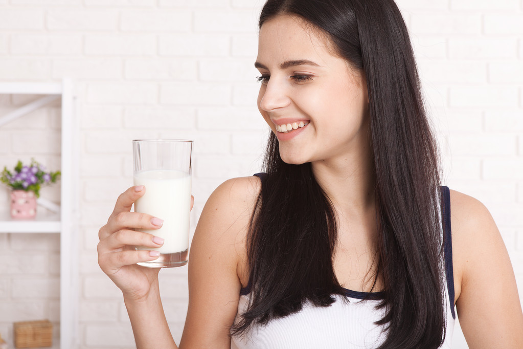 Felice giovane donna che beve latte - Foto, immagini