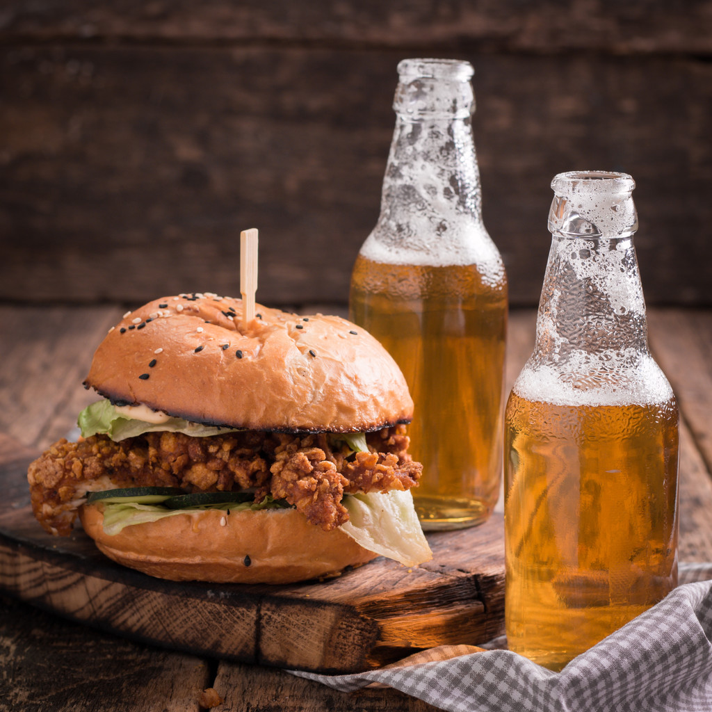 frischer und schmackhafter Hamburger mit einem Bier auf einem Holztisch. - Foto, Bild