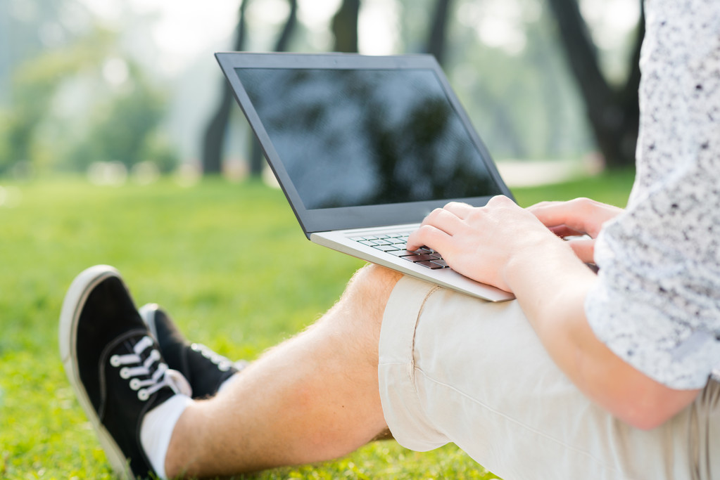 молодий чоловік в парку з ноутбуком
 - Фото, зображення
