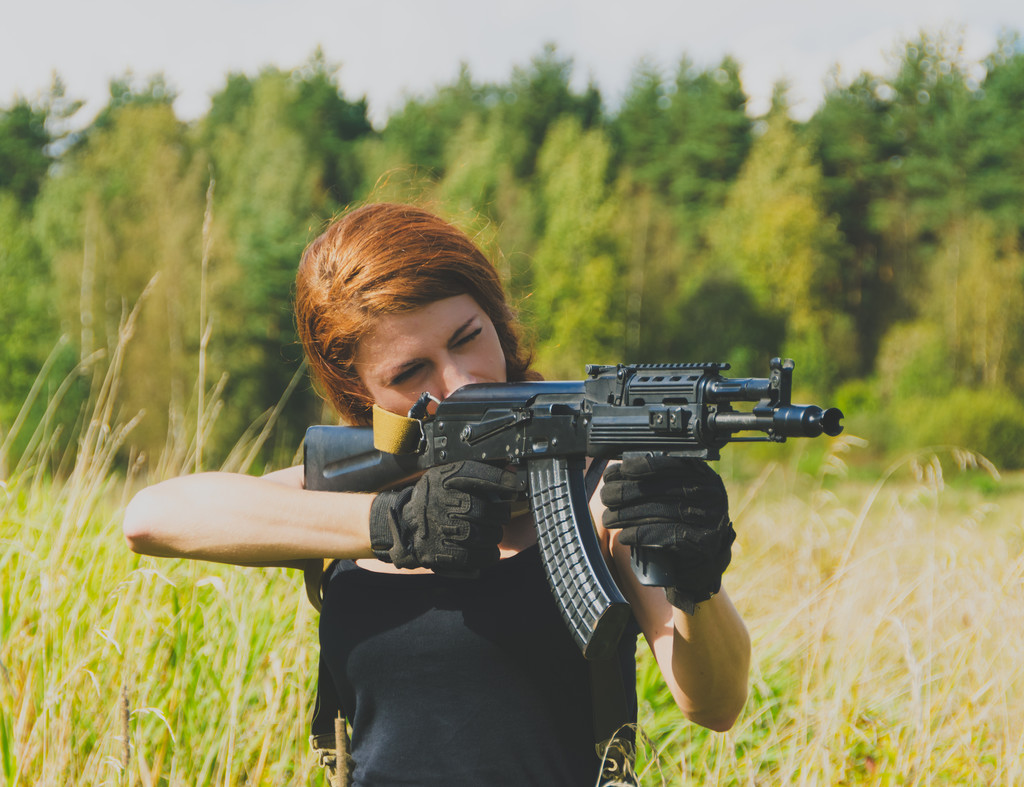 руда дівчина з пістолетом в руці
 - Фото, зображення