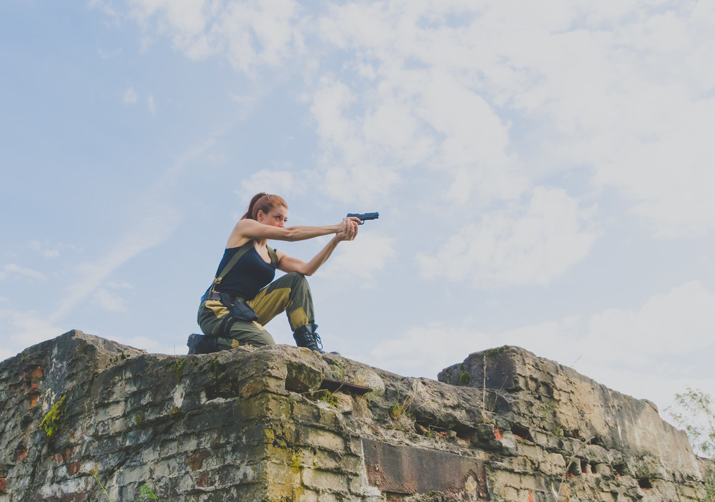 egy pisztolyt tartó ellen az égen vörös hajú lány katonák - Fotó, kép