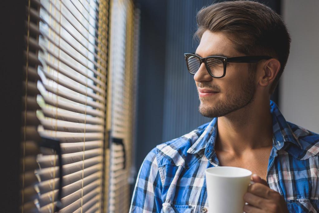 freelancer holding cup of coffee and looking in the window - Photo, Image