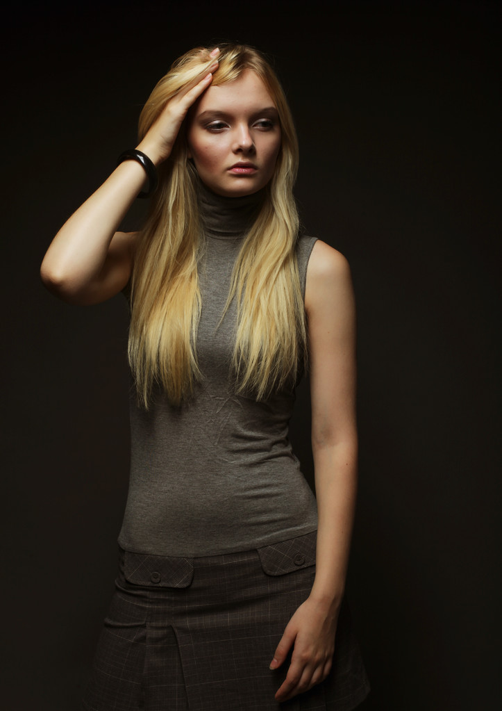Portret van mooi jong blond meisje in zwarte jurk. - Foto, afbeelding