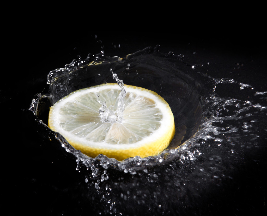Zitronenscheibe spritzt in Wasser. - Foto, Bild