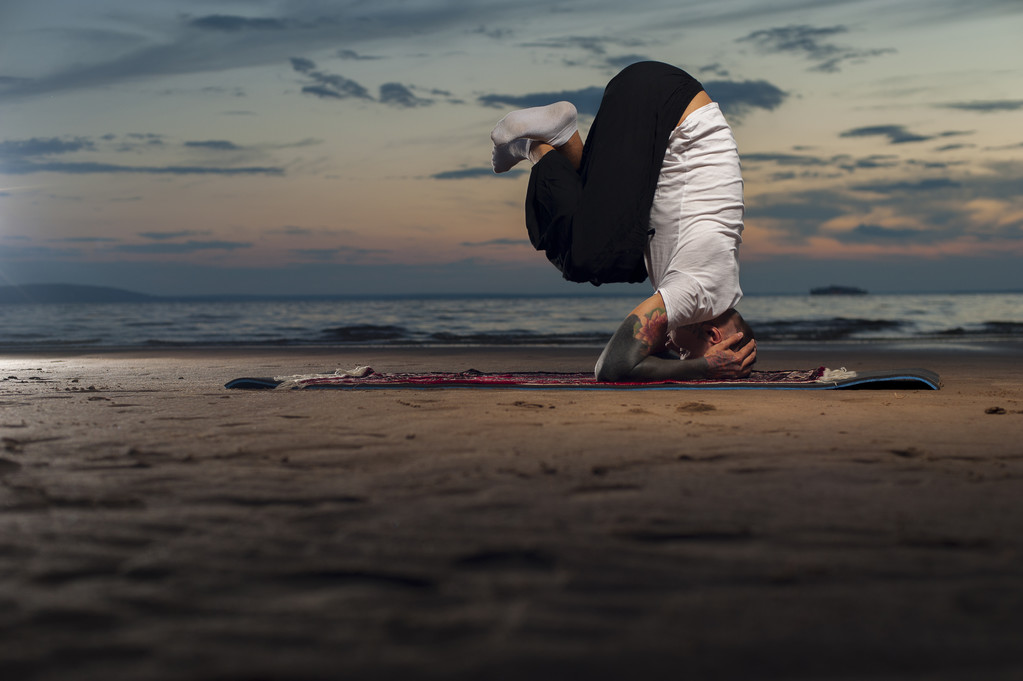 Hombre de yoga flexible haciendo cabecera en la playa
 - Foto, Imagen