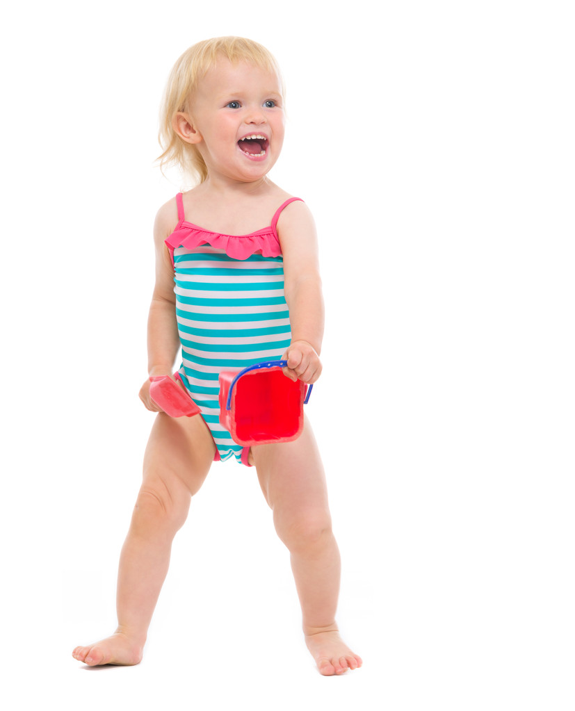 Baby girl in swimsuit holding bucket and shovel - Photo, Image