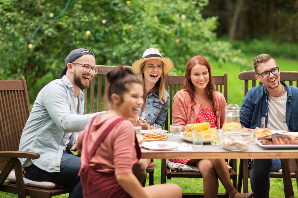 счастливые друзья, ужинающие на вечеринке в летнем саду
 - Фото, изображение
