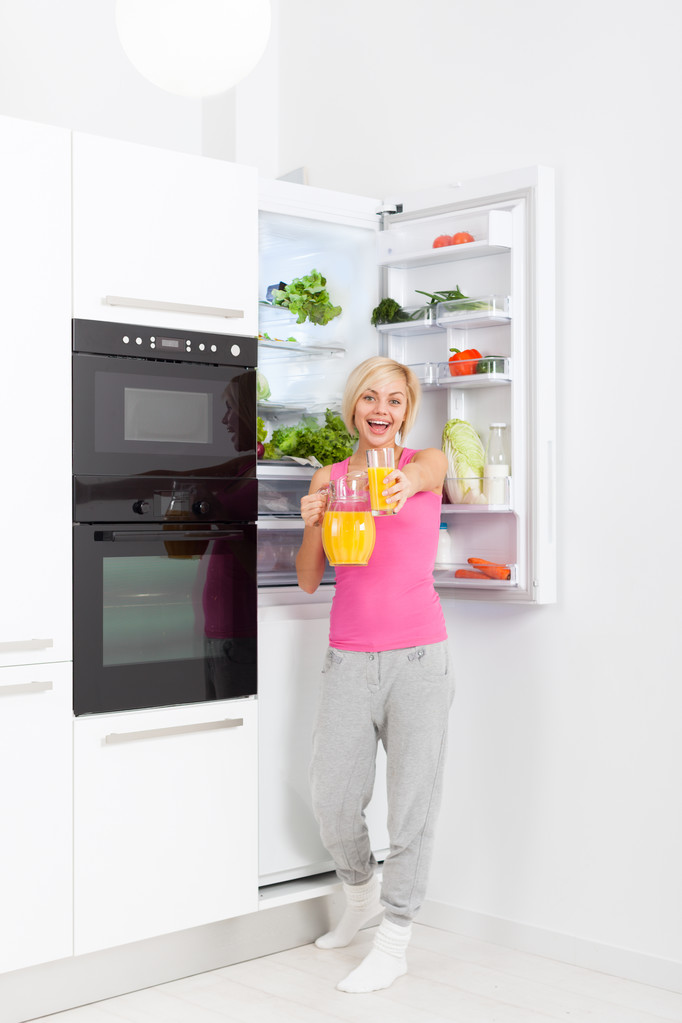woman drink orange juice hold glass refrigerator - 写真・画像