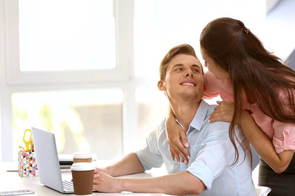 Όμορφο ζευγάρι σερφάρισμα στο διαδίκτυο σε φορητό υπολογιστή στο γραφείο - Φωτογραφία, εικόνα